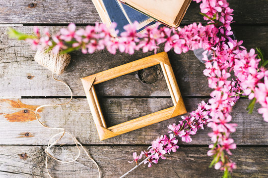 Spring flowers frame and book on a old wooden background