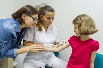 Doctor makes vaccination to a child. Inoculation in the shoulder, in the hospital. Medicine,...