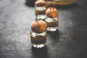 Pani Puri is an indian road side chat item - 4 stuffed puris kept over small glasses filled with mint water © Arundhati