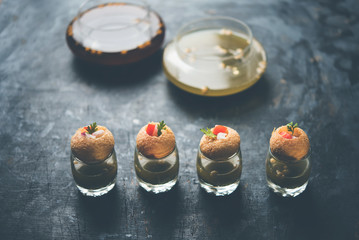 Pani Puri is an indian road side chat item - 4 stuffed puris kept over small glasses filled with mint water © Arundhati