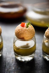 Pani Puri is an indian road side chat item - 4 stuffed puris kept over small glasses filled with mint water