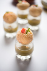 Pani Puri is an indian road side chat item - 4 stuffed puris kept over small glasses filled with mint water