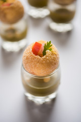 Pani Puri is an indian road side chat item - 4 stuffed puris kept over small glasses filled with mint water