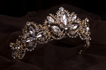 gold diadem with diamonds isolated on the fabric