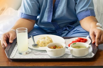 Patient and hospital concept - Asia man patient with iv solution eating healthy food for patient on bed in hospital and copy space
