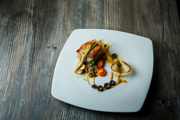 roasted meat decorated with grilled vegetables and black olive