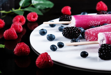 Icecream with blackberry and raspberry isolated on black background. Beautiful mockup wih chocolate, icecream and fruits.