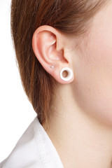 young woman with flesh tunnel ear lobe piercing                              