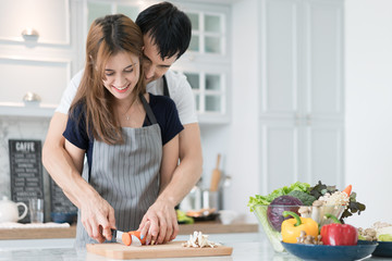 Obraz na płótnie Canvas Young beautiful couple in kitchen. Family of two preparing food. Couple making delicious salad. Cooking hobby lifestyle concept.