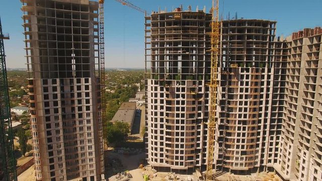Aerial shoot of construction site with tower cranes. Drone footage