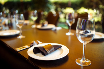 Sparkling glassware stands on long table prepared for wedding dinner.