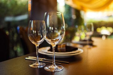 Sparkling glassware stands on long table prepared for wedding dinner.