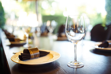 Sparkling glassware stands on long table prepared for wedding dinner.