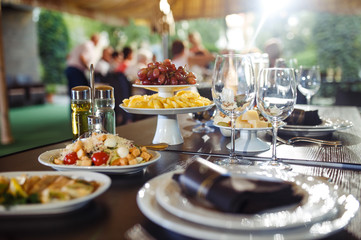 Sparkling glassware stands on long table prepared for wedding dinner