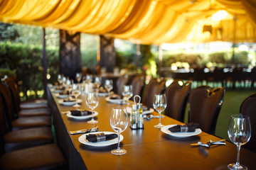 Sparkling glassware stands on long table prepared for wedding dinner