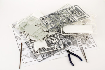 kit for assembling gray plastic car model on white background