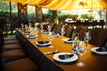 Sparkling glassware stands on long table prepared for wedding dinner