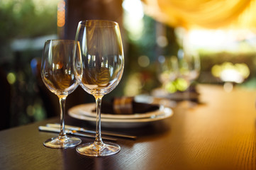 Sparkling glassware stands on long table prepared for wedding dinner