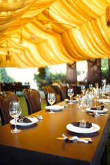 Sparkling glassware stands on long table prepared for wedding dinner