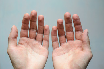Top view of two empty hands over grey background. Wrinkled palms panhandle concept