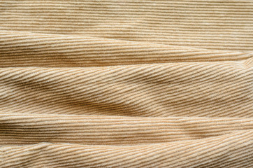 Texture of Soft Velvet Fabric with Folds Closeup. Texture of Beige Velvet Clothes. Textile Fabric of Corduroy as Background