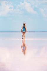 Girl stands by pink salt lake