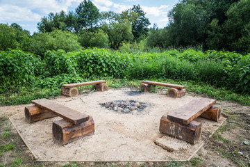 wooden benches near an extinct fire