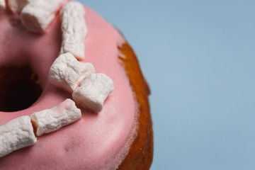 Pink donut with marshmallows on a blue background