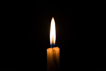 Candle light flame against black background. Concept of memory, remembrance, mourning, grief, and...
