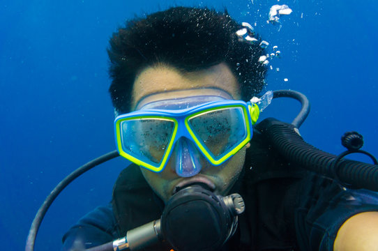 Scuba diving man with mask and underwater wetsuit take selfies photo