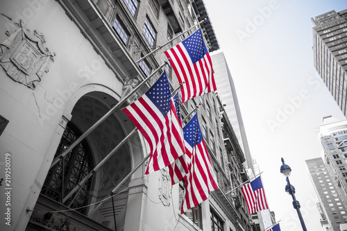 New York City, United States. Multiple American flags waving from the facade of a building