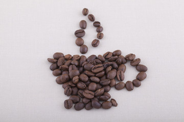 Smoke and coffee cup shaped coffee beans on textile background