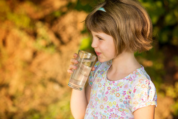 Little girl kid with glass of water in morning, drink every day. Concept of healthy habits