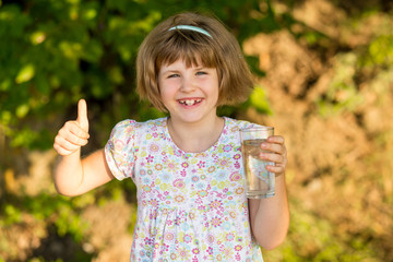 Little girl kid with glass of water in morning, drink every day. Concept of healthy habits