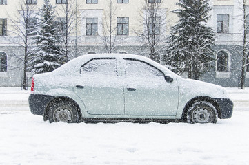 A car parked on the street, covered with snow