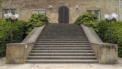Fototapeta premium Old stony stairs lead to the wooden door of wolfsburg castle