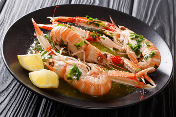 Delicious expensive food. langoustine, scampi with lemon and melted butter with parsley and garlic close-up. horizontal