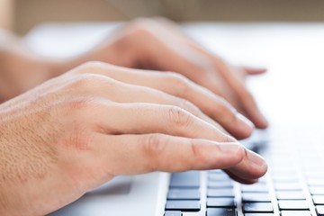 Closeup of a Man Typing on a Laptop