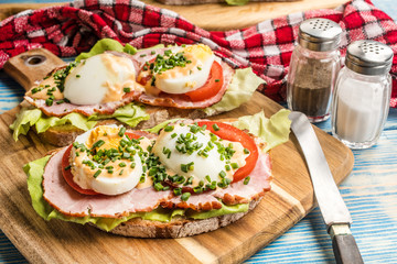 Sandwich with tomatoes, eggs and lettuce.