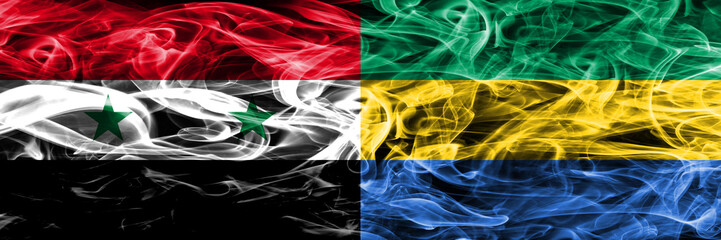 Syria vs Gabon smoke flags placed side by side. Thick colored silky smoke flags of Syrian and Gabon