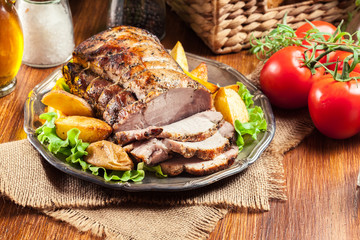 Roasted pork loin with baked potatoes and herbs - 219257402