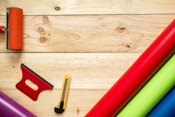 Vinilos de colores	sobre fondo de madera con sus instrumentos necesarios