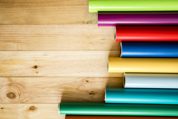 Vinilos de colores	sobre fondo de madera con sus instrumentos necesarios