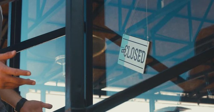 4K CINEMAGRAPH - SEAMLESS LOOP. CU closed sign hanging on the entrance door of a small cafe. Out of business