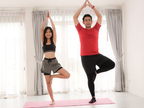 Asian Couple Doing Yoga At Home, Lifestyle Concept.