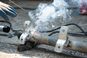 close up technician welding metal pole, dangerous worker.