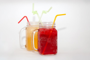  Cherry and orange juice in a glass jar with a straw on a white background