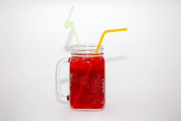  Cherry juice in a glass jar with a straw on a white background