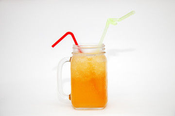  Orange juice in a glass jar with a straw on a white background