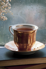 A cup of tea in front of rainy window